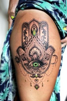 a woman's thigh with a hamsa tattoo on it