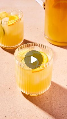 two glasses filled with drinks sitting on top of a table