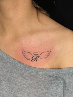 a woman's chest with a small tattoo on the left side of her neck