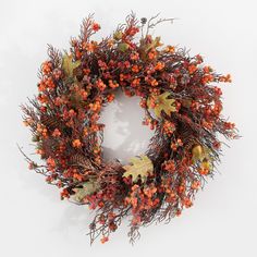 a wreath with orange berries and pine cones on white background for decoration or as part of an autumn display