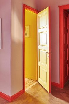 an open yellow door in a pink room