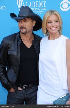 a man and woman standing next to each other on the red carpet at an event