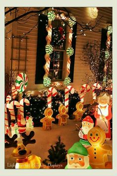 christmas decorations in front of a house with lights and candy canes on the windowsill