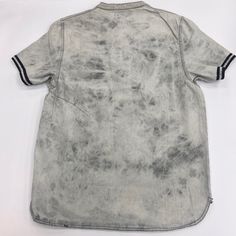 the back of a shirt that has been dyed with grey dye and black stripes on it