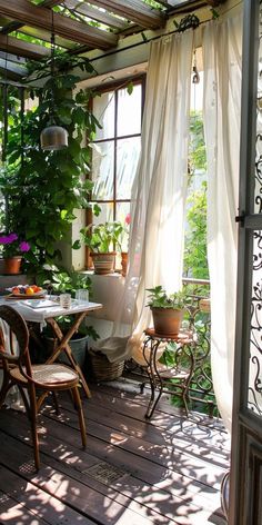 a table and chairs on a wooden deck with potted plants in the window sill