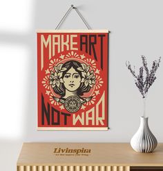 a poster hangs on the wall next to a vase with flowers