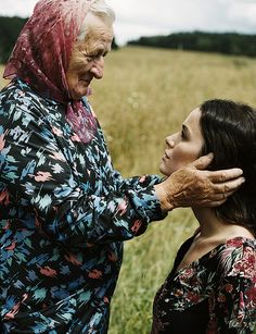 two women standing in a field with one touching the other's ear