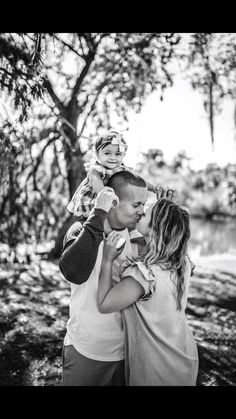 black and white photograph of two people hugging each other in front of trees with the sun shining on them