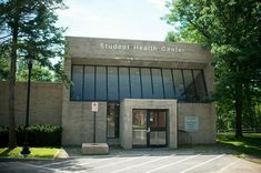 the front entrance to a building with trees in the background