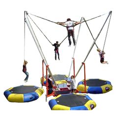 three people are doing tricks on an inflatable trampoline while another person jumps off the trampoline