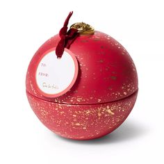 a red ball with gold splatters on it and a tag hanging from the top