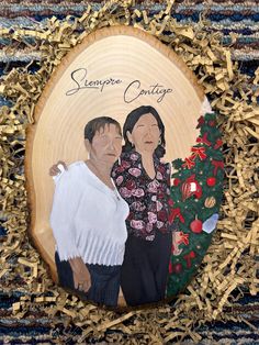 an image of a couple holding each other in front of a christmas ornament