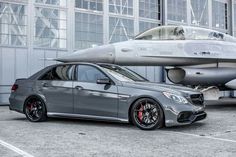 the mercedes benz amg is parked in front of an airplane