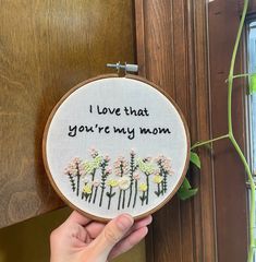 someone is holding up a cross - stitch hoop with the words i love that you're my mom