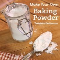 a wooden table topped with a glass jar filled with baking powder next to a spoon