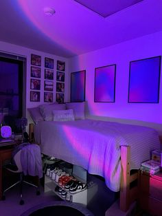 a bedroom with purple lighting and pictures on the wall