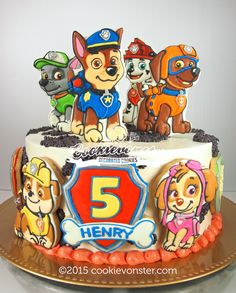 a cake that is decorated with cartoon characters on it and has the number five on top