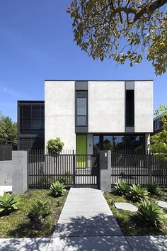 a modern house with black and white architecture on the outside, surrounded by greenery