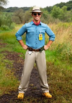 a man standing on a dirt road with his hands on his hips