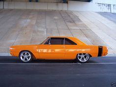 an orange muscle car parked in a parking lot