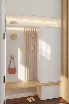 a room with white cupboards and wooden flooring next to a wall mounted shelf