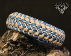 two blue and white braided rings sitting on top of a rock