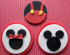 three decorated cookies with mickey mouse faces on top of each other, one is red and the other is black