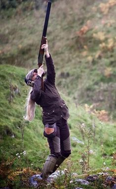 a woman holding an umbrella up in the air