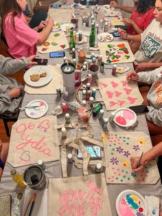 a group of people sitting around a table with paper plates and napkins on it