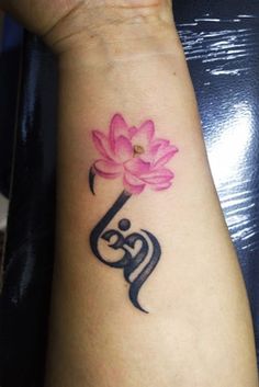 a woman's arm with a pink flower on it and the word love written in arabic