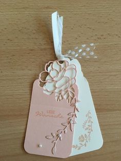 a pink tag with white flowers on it