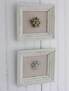 two framed pictures hanging on the wall next to each other, one with a brooch