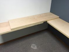 a corner bench with plywood on the top in an empty room or waiting area