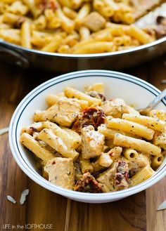 two bowls filled with pasta and meat on top of a wooden table