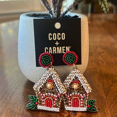 a pair of earrings sitting on top of a table next to a potted plant