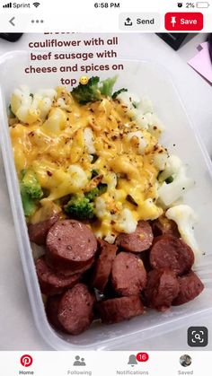 a plastic container filled with sausage and broccoli on top of a white table