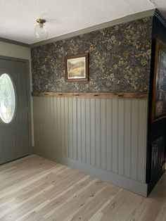 an empty room with wood floors and wallpaper on the walls is pictured in this image