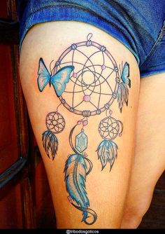 a woman's thigh with a dream catcher tattoo design on it and butterflies flying around