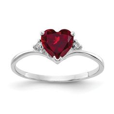 a heart shaped ring with two diamonds on the sides and a red stone in the middle