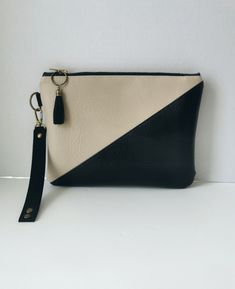 A stylish vegan leather asymmetric two-tone clutch in stone white and black, featuring a quality brass zip adorned with a faux black suede tassle with antique gold metal work - lined in black cotton drill. This clutch also features a beautifully soft black faux suede strap with a detachable brushed gold lobster claw fastening so you can to wear it with or without the strap.  Three antique gold metal rivets feature on the strap complimenting the other gold metal work on the bag. The size of the p Modern Black Clutch With Zipper Closure, Origami Bag, Different Shades Of Red, Metal Work, Small Purse, The Pouch, Soft Black, Clutch Purse, Clutch Handbag