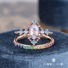 a ring with an oval cut diamond surrounded by multi - colored stones