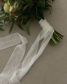 the bride's bouquet and her wedding ribbons are laid out on the floor next to each other