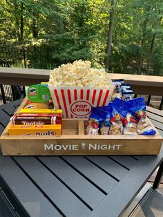 a tray filled with popcorn and snacks on top of a table