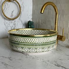 a bathroom with marble counter top and gold faucet