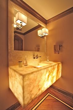 an image of a bathroom setting with lights on the sink and mirror above it that is lit up