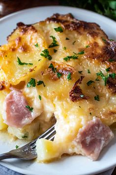 ham and cheese casserole on a white plate with a fork