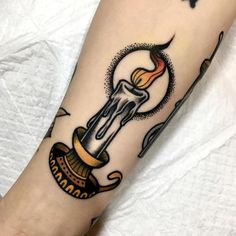 a tattoo on the leg of a person with a candle and an ornament