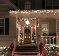 a house decorated for christmas with lights and garlands on the front door, stairs and porch