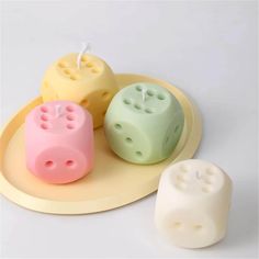 three dice shaped candles sitting on top of a plate