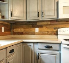 a white stove top oven sitting inside of a kitchen next to wooden cabinets and cupboards